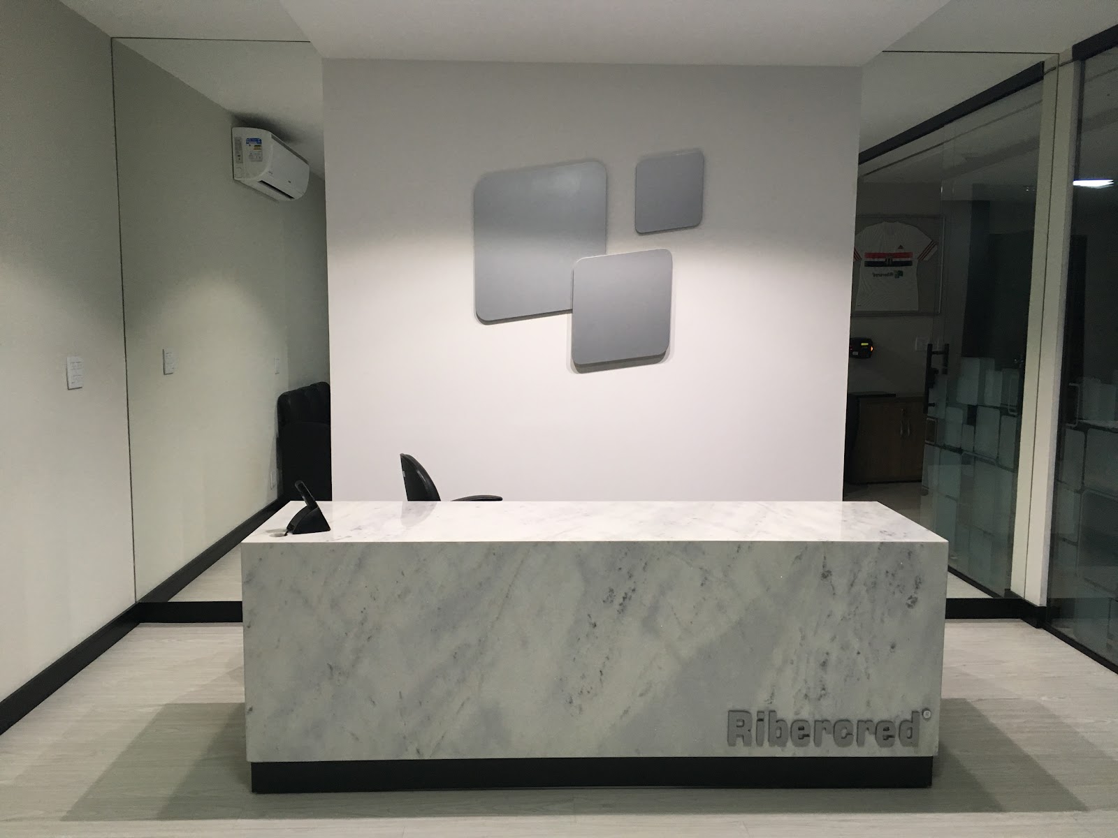 Ribercred — recepção com balcão em mármore e identidade visual · ECOARTT